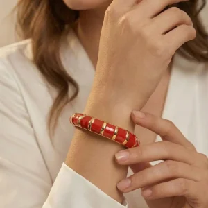 Pulsera color dorado con acabados rojos 106404
